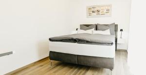 Cama en habitación con paredes blancas en Suite by Silvy, en Vipiteno