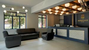 een wachtkamer met een bank en twee stoelen bij Heritage Suites in Mysore