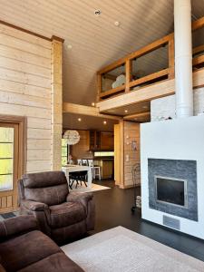 Una sala de estar con un sofá y una chimenea. en AureenHelmi, en Aurekoski