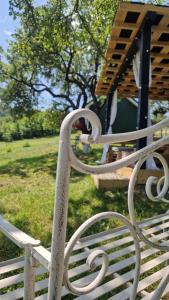 a white park bench sitting in a field at Tiny Nest in Filioara
