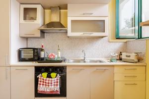 une cuisine avec un évier et un micro-ondes dans l'établissement Casa Vacanze La Cupoletta, à Meta