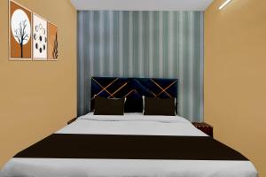 Un dormitorio con una cama grande con cabecero azul. en Hotel O Lotus Inn, en Faridabad