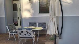 un patio avec une table, des chaises et un parasol dans l'établissement Casa Vacanze La Cupoletta, à Meta
