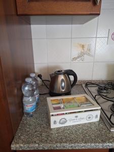 a tea kettle and a box on a kitchen counter at B&B Casa Piras IUN3880 in Barùmini