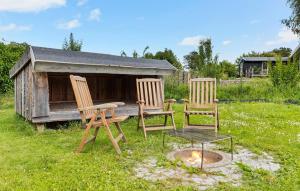 three chairs and a table in front of a dog house at 2 Bedroom Gorgeous Home In Glesborg in Glesborg +9 photos