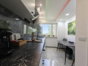 a kitchen with a black counter top and a table at Modern Apartments Neuburg US - NEU - 2 Zimmer, Komfort, Top Ausgestattet, Smart TV, Wi-Fi in Neuburg an der Donau +28 photos
