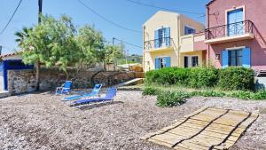 a pair of blue chairs and a house at anatoli by the sea in Skala Mistegnon
