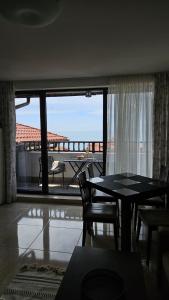 a living room with a table and chairs and a balcony at PSB Apartments in Etara 2 & 3 Complex Sveti Vlas in Sveti Vlas