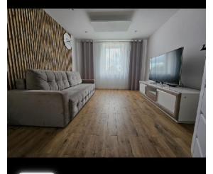 a living room with a couch and a flat screen tv at Apartament Sikorskiego 27 in Ełk