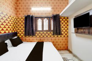 une chambre avec un lit et une télévision à écran plat dans l'établissement HOTEL O Happy Inn, à Jabalpur