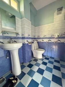 a blue and white bathroom with a sink and a toilet at Fewa Homestay and Retreat in Pokhara +15 photos