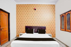 une chambre avec un lit et un mur dans l'établissement HOTEL O Happy Inn, à Jabalpur 21 autres photos
