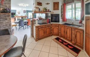 Una cocina con gabinetes de madera y una mesa y sillas. en Charmante Maison En Vendée, en Commequiers