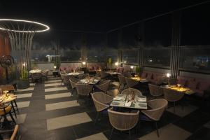a restaurant with tables and chairs at night at Ramada Encore by Wyndham Chandigarh Zirakpur in Zirakpur