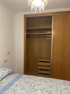 a bedroom with a closet with a bed and a chandelier at Oasis Ilicitano in Elche