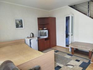 a room with a bed and a microwave and a refrigerator at Мини-отель Версан in Cholpon-Ata