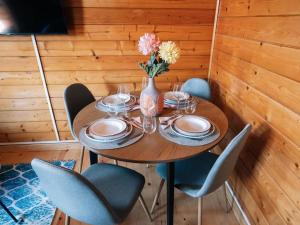 un tavolo in legno con sedie e un vaso con fiori di Casa de campo entre viñedos a Laguardia
