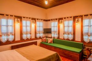a bedroom with a green bench and windows at Saffronia1900 Butik Otel in Safranbolu +40 photos