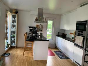 a kitchen with white cabinets and a black counter top at Villa Bliss in Surte