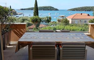 een tafel en stoelen op een balkon met uitzicht op het water bij Apartman Twins 2 by Villas Guide in Ðurinići
