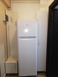 ein weißer Kühlschrank steht in einem Raum mit einem Zimmer in der Unterkunft Dancing soul studio in Bukarest