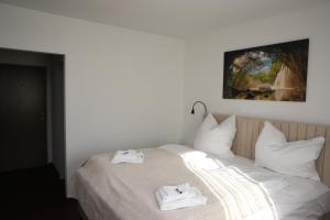 a white bed with two towels on top of it at Hotel Garni Alte Post in Schallbach