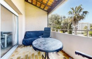 a table and a chair on a balcony at Pet Friendly Apartment In Hyères in Hyères