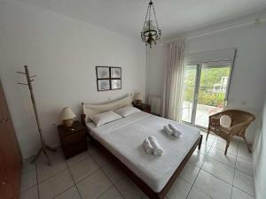 a bedroom with a bed with two towels on it at Villa Georgia Poseidi in Kalandra