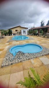two swimming pools in a yard with a building at - Belezas do Monte Chalé e Suíte- La na Roça in Monte das Gameleiras +17 photos