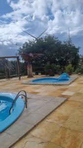 a swimming pool with two slides in a resort at - Belezas do Monte Chalé e Suíte- La na Roça in Monte das Gameleiras