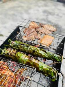 a bunch of food on a grill with meat at Thung Din Homestay in Phủ Nho Quan