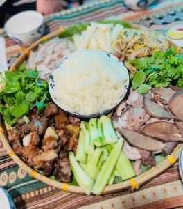 a plate of food with rice and vegetables on a table at Thung Din Homestay in Phủ Nho Quan