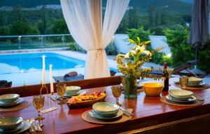 a table with food and candles on it with a pool at Villa Filomena - Omis by Villas Guide in Blato na Cetini