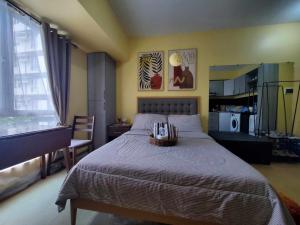 a bedroom with a bed with a basket of books at Studio Unit Pool View 3rd Floor at Centrio Tower beside Ayala Mall, CDO in Cagayan de Oro +23 photos