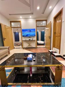 ein Wohnzimmer mit einem Tisch in der Mitte eines Zimmers in der Unterkunft Luxury Family Villa in Islamabad