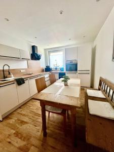 a kitchen with a wooden table and chairs in a room at Casa Sophia - stadtnahe, großzügige Ferienwohnung in Regensburg