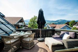 a patio with a table and chairs and an umbrella at Strömbergs Gunnar in Oberstaufen