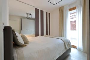 ein Schlafzimmer mit einem weißen Bett und einem Fenster in der Unterkunft Portopiccolo Apartments in Sistiana + 267 Fotos