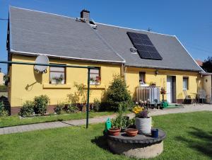 a yellow house with solar panels on the roof at Ferienhaus Schlenker in Neustadt in Sachsen
