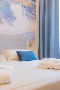 a white bed with a painting on the wall at Hotel Belvedere in Forte dei Marmi