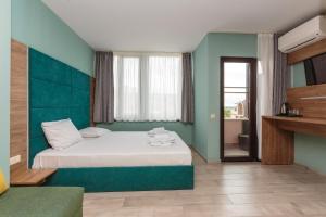 a bedroom with a bed with a green wall at All-inclusive Holiday Apartments in Tarsis Hotel & Aquapark in Sunny Beach +28 photos