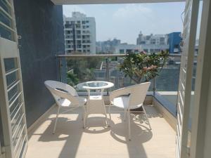 ein Balkon mit einem Tisch und Stühlen auf einem Balkon in der Unterkunft EXPAT STYLED 2 BHK IN BANER BALEWADI , Pune in Pune