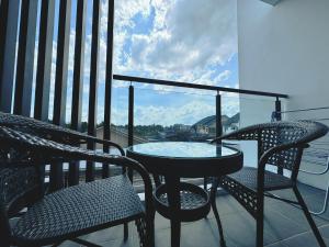 a balcony with a table and chairs and a view at Kuching Cozy Comfort 07 - Home Stay GEM Suites 7 Pax near Airport & Saradise in Kuching