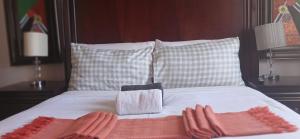 a bed with two towels and pillows on it at Rochilla Guesthouse in Welkom