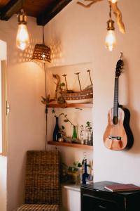 a guitar hanging on a wall in a room at Alloro casa storica in Arcola