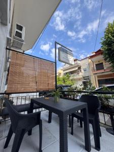 a black table and chairs on a balcony with a view at Mariam Apartment in Nea Moudania