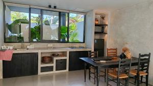 チャングーにあるHanupis Canggu Apartment Villaのキッチン(テーブル付)、大きな窓が備わります。