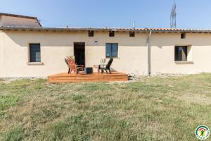 a house with two chairs sitting on a deck at Gîte la selve d'autan in Caraman