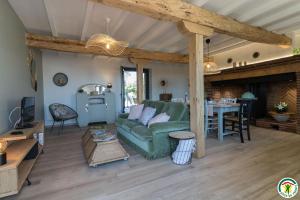 a living room with a green couch and a table at Gîte la selve d'autan in Caraman