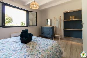 a bedroom with a bed and a window and a dresser at Gîte la selve d'autan in Caraman